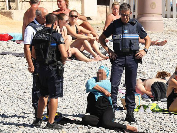 French police make woman remove clothing on Nice beach following burkini ban French police make woman remove clothing on Nice beach following burkini ban