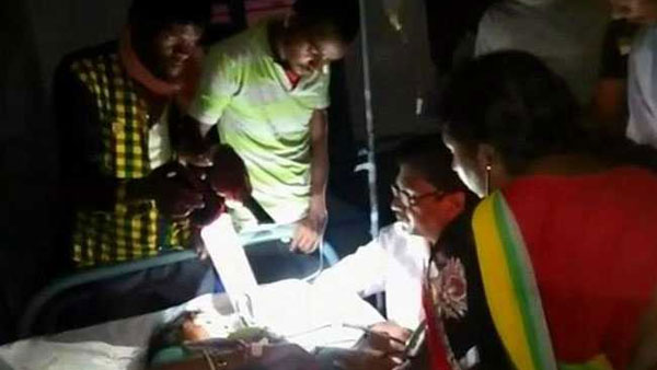 Power cuts make doctors treat patients under flashlights Power cuts make doctors treat patients under flashlights