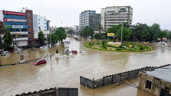 బిడ్డను తలపై ఎత్తుకుని పీకల్లోతు నీళ్లలో నడుస్తూ
