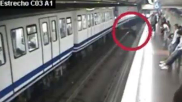 A Woman distracted by mobile phone falls in front of oncoming train A Woman distracted by mobile phone falls in front of oncoming train