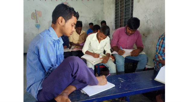 చేతులు లేకున్నా కాళ్ళతో రాస్తూ చదువుతున్న కుర్రాడు