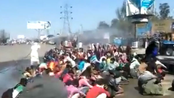 Migrants returning to Bareilly in UP forced to take bath in the open with sanitiser Migrants returning to Bareilly in UP forced to take bath in the open with sanitiser