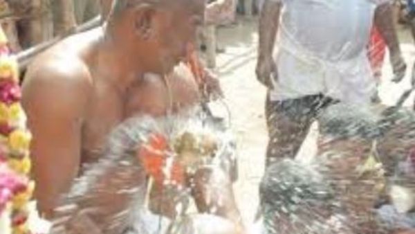 Priest smashing coconuts on head.. Priest smashing coconuts on head..