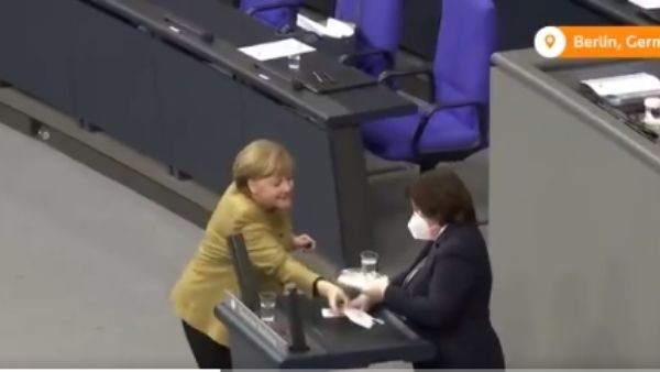 Angela Merkel panics as she forgets her face mask during parliament session Angela Merkel panics as she forgets her face mask during parliament session