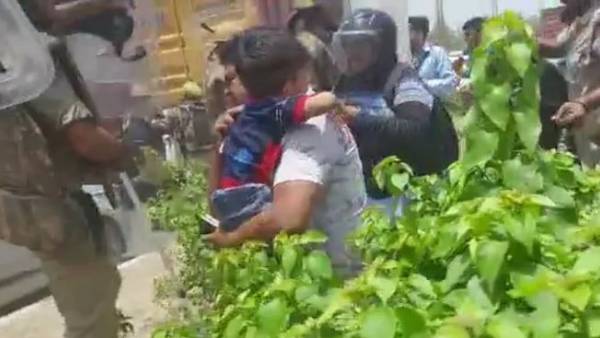 Man holds child, runs for cover as Agnipath protesters pelt stones Man holds child, runs for cover as Agnipath protesters pelt stones