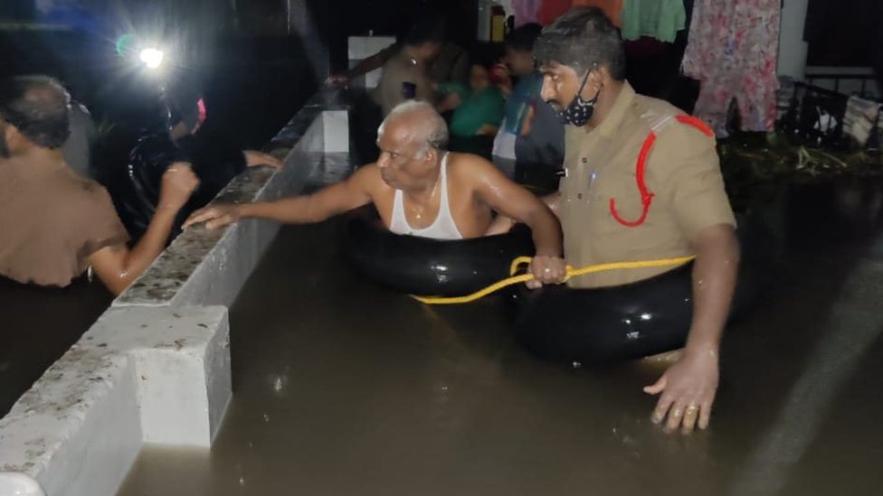 నీట మునిగిన ఇంటి నుంచి వయోధికుడిని రక్షిస్తున్న పోలీసులు నీట మునిగిన ఇంటి నుంచి వయోధికుడిని రక్షిస్తున్న పోలీసులు