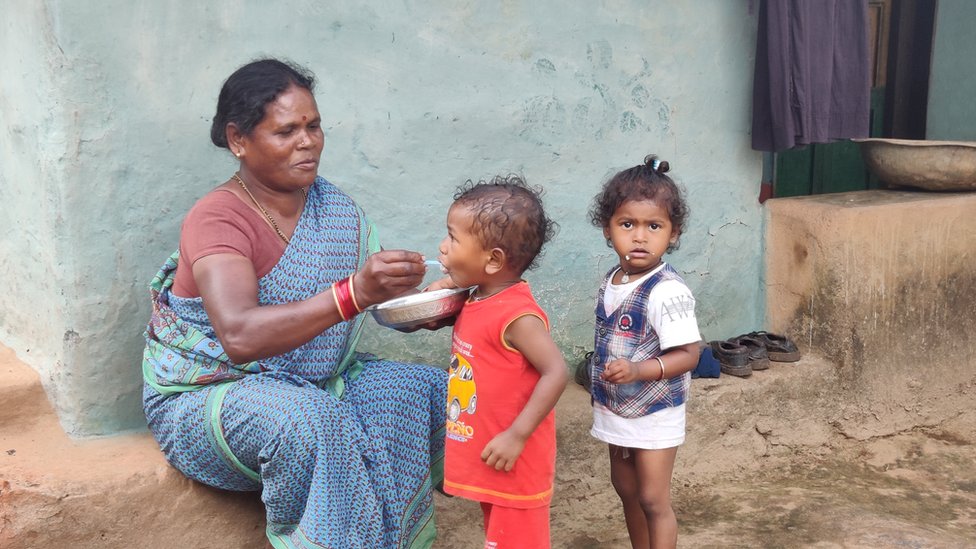 చిన్నారులకు అన్నం తినిపిస్తున్న మహిళ చిన్నారులకు అన్నం తినిపిస్తున్న మహిళ
