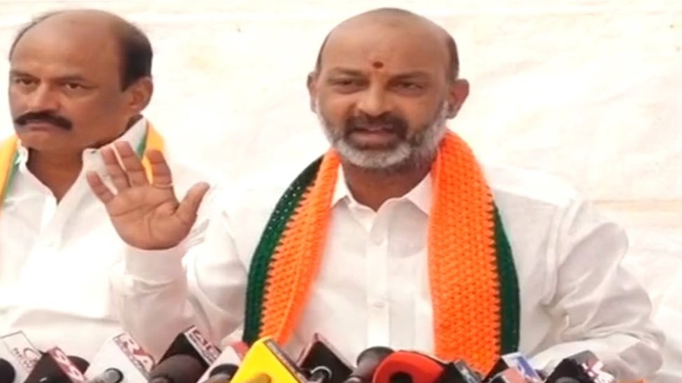 అమిత్ షా బూట్లు బండి సంజయ్ తెచ్చిచ్చిన వీడియో వైరల్... దీనిపై ప్రత్యర్థులేమన్నారు, రాష్ట్ర బీజేపీ అధ్యక్షుడు ఏమ