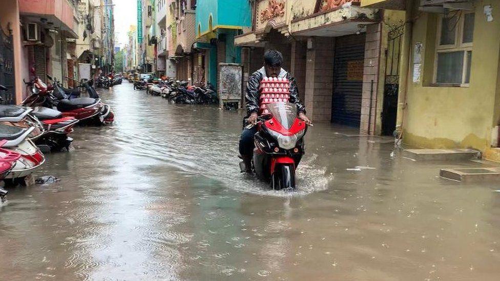 వరద నీటిలో బైకు నడుపుతున్న వ్యక్తి వరద నీటిలో బైకు నడుపుతున్న వ్యక్తి